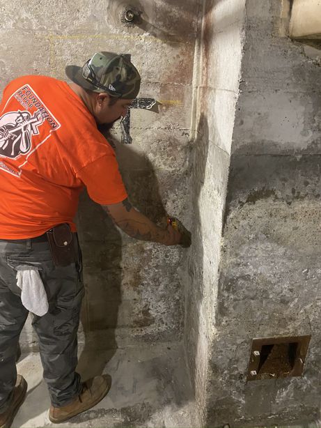 Below-grade waterproofing testing being performed on a residential basement perimeter wall.