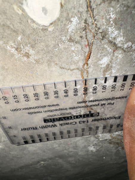 Close-up of crack measurement being performed before crack injection repair.