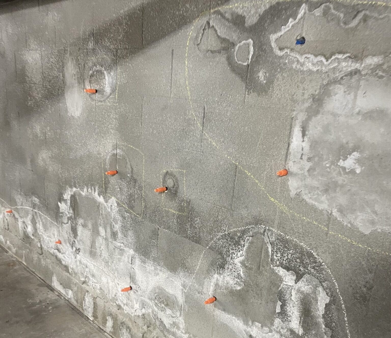 Efflorescence on a subterranean garage wall — white chalky mineral deposits indicating excessive water intrusion and poor waterproofing.