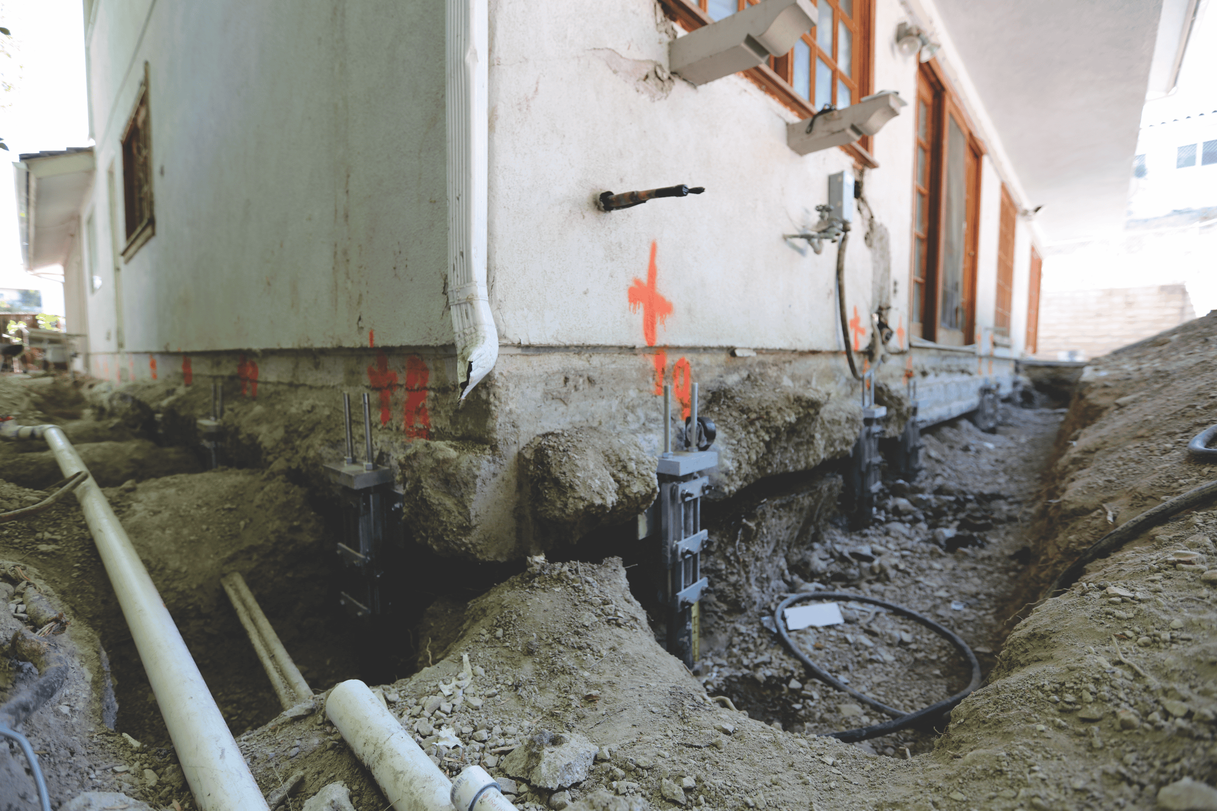 Steel push pier installation on a residential foundation.