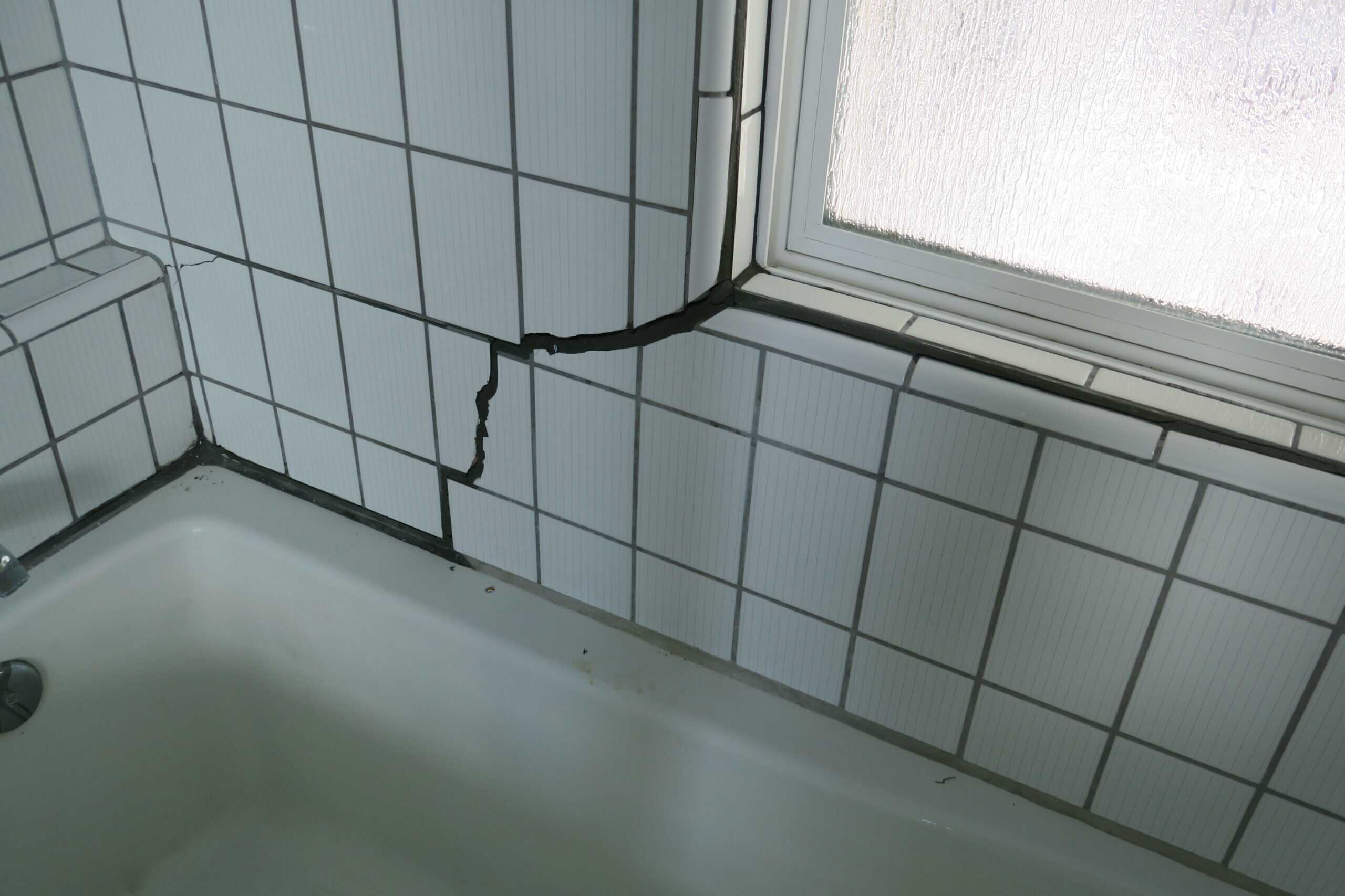 Interior crack in tile wall caused by foundation settlement โ a common visual warning sign of foundation movement