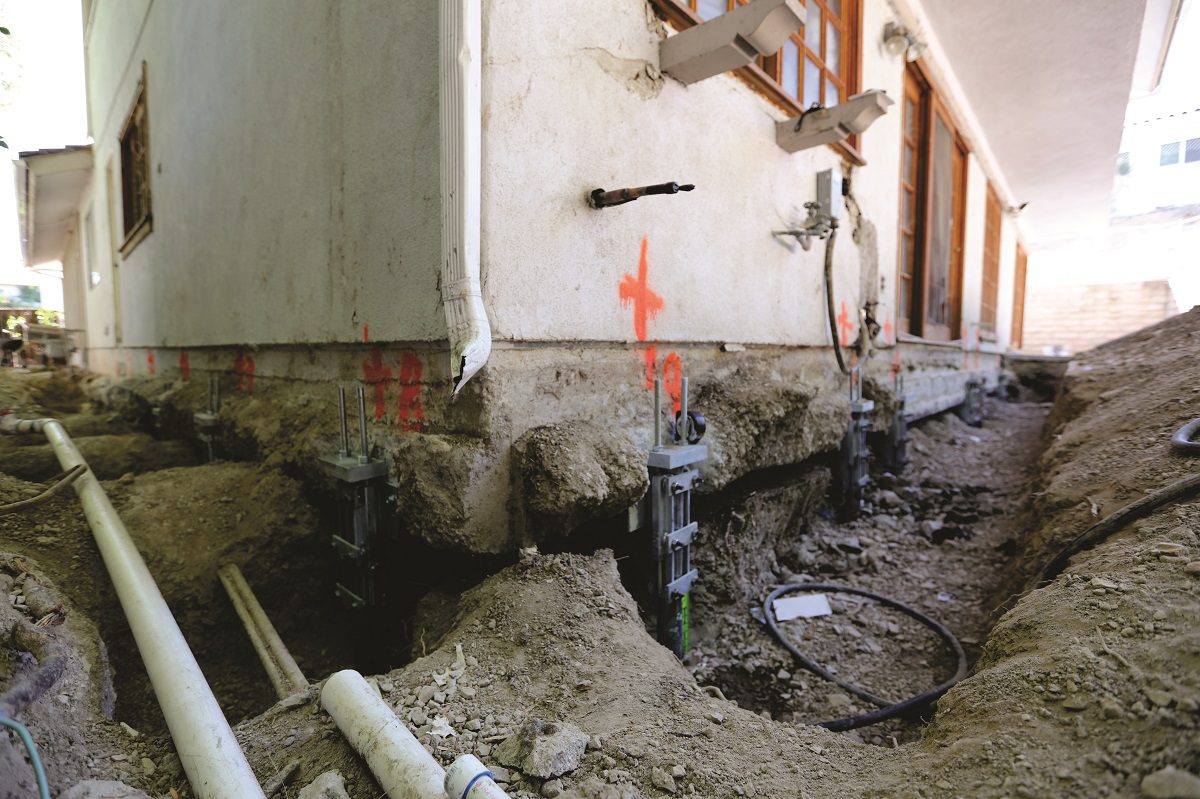 Steel ECP push piers installed along a residential foundation after a six-inch structural lift