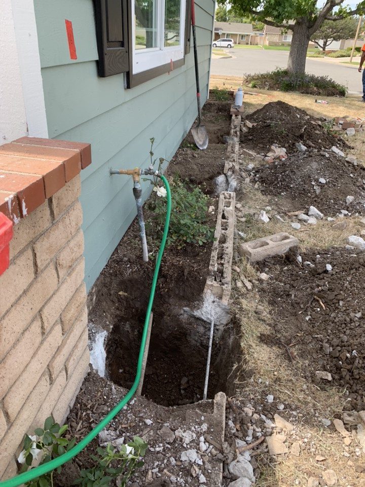 Open excavation along a residential foundation in preparation for push pier installation