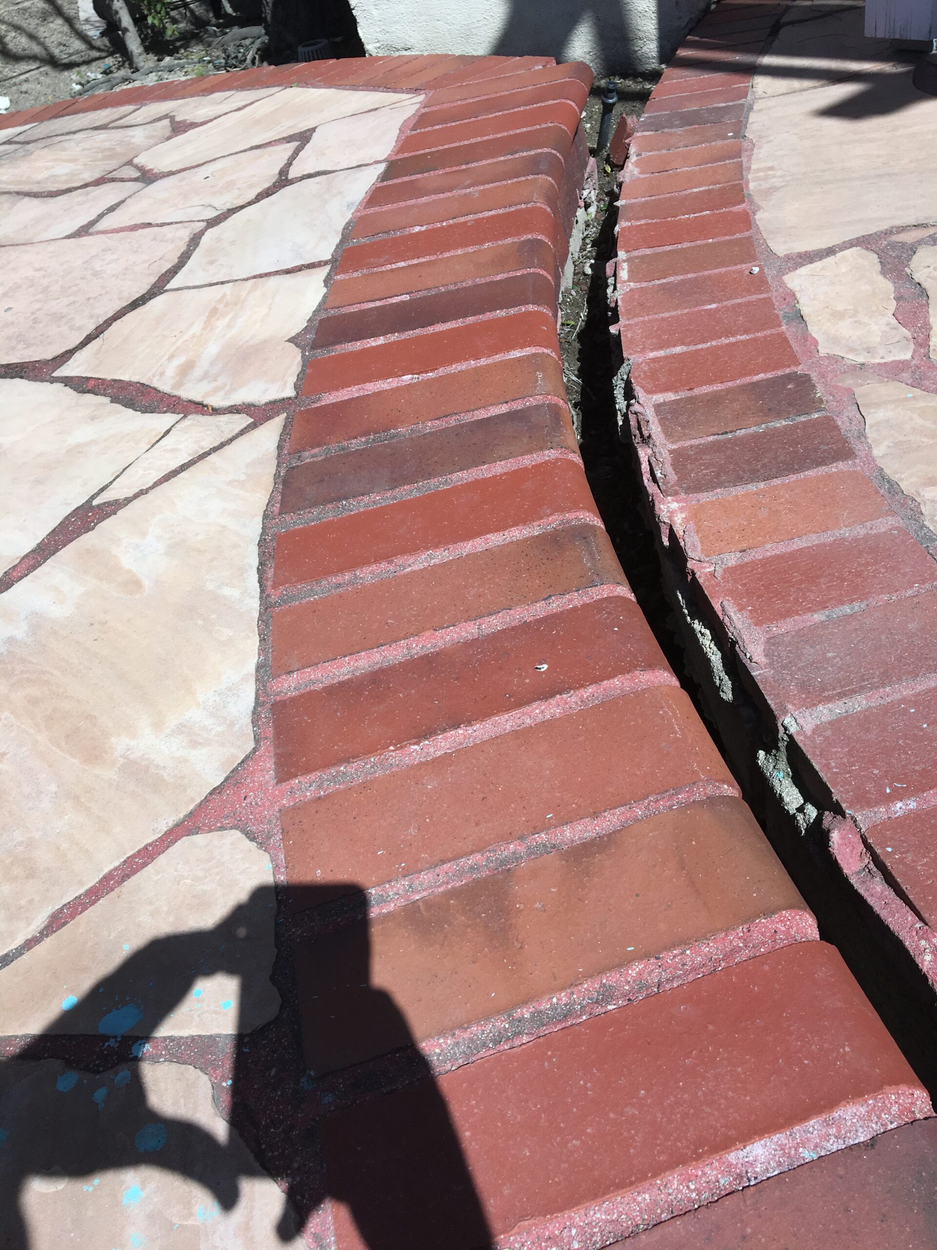 Pool deck sinking and slipping downhill at a hillside property, a common sign of slope movement on Woodland Hills canyon ridges